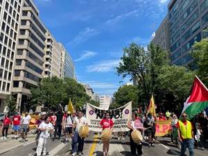 A group of people marching in a street

Description automatically generated